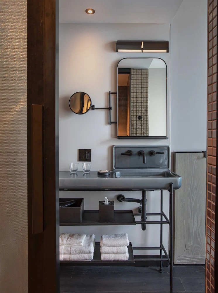 A guest bathroom at the Moxy AC Hotel, Downtown Los Angeles, lit by a custom PTY vanity fixture
